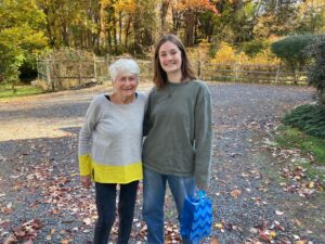 Auf dem Bild sind eine ältere Dame und eine junge Frau zu sehen, die sich freundschaftlich umarmen
